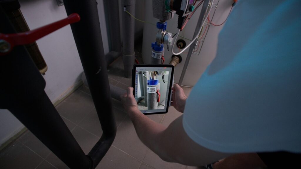 HVAC field service technician scanning a boiler barcode with a mobile device