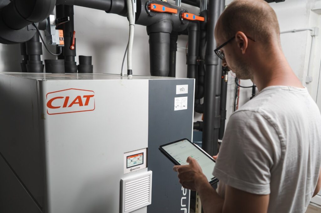 HVAC field service technician inspecting an industrial heating device with a tablet